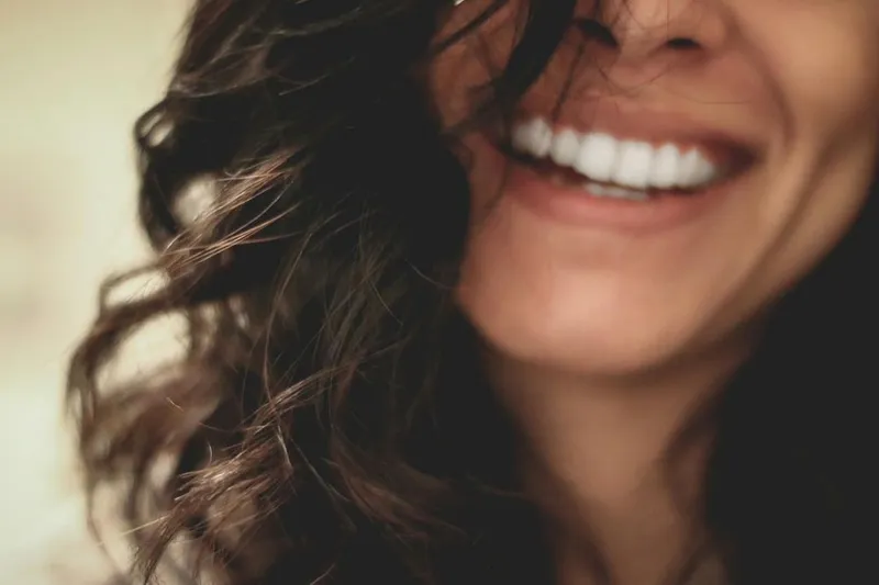 A close, warm portrait of a woman smiling naturally