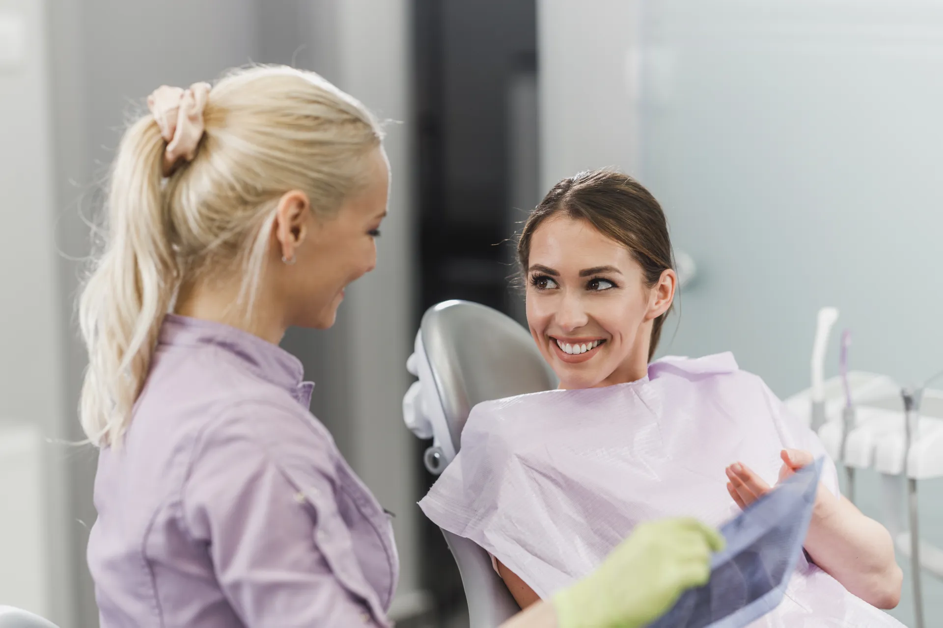 A smiling patient talking with her dentist during a check-up appointment