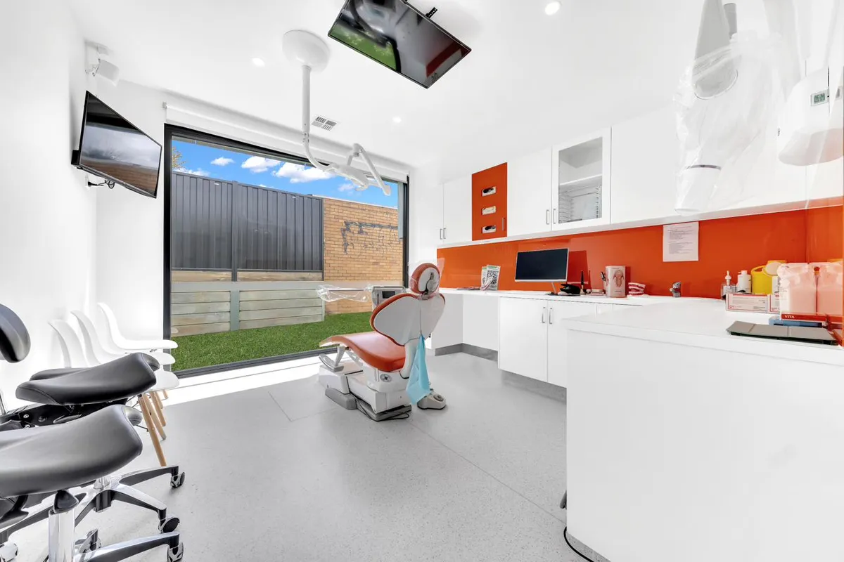 Treatment room with reclined dental chair, natural light and a calm white interior at a Magical Smiles clinic