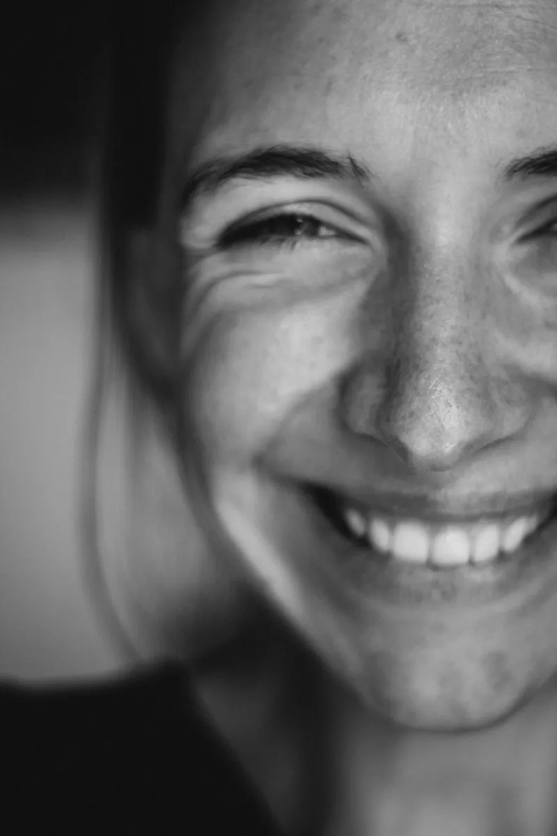 A close, candid smile showing the top teeth and a small edge of gum