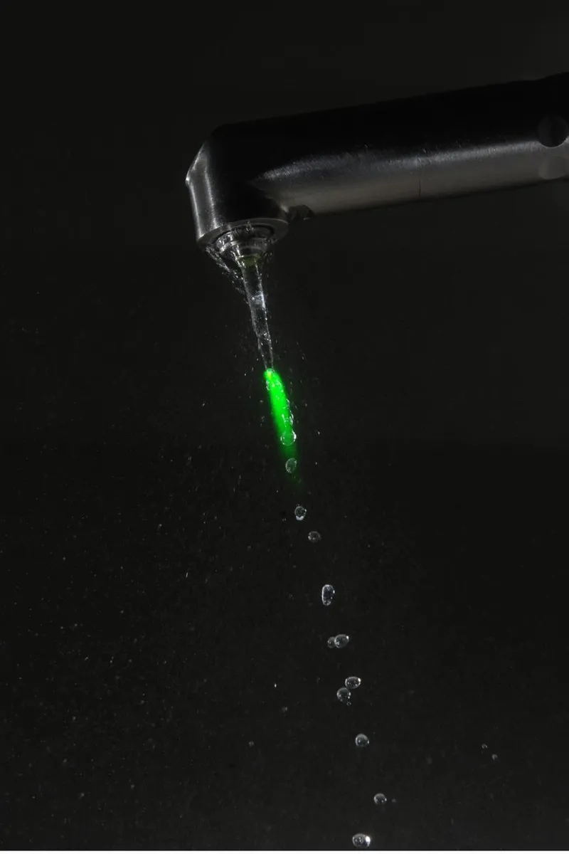 Fotona dental laser handpiece firing its beam through a fine stream of water