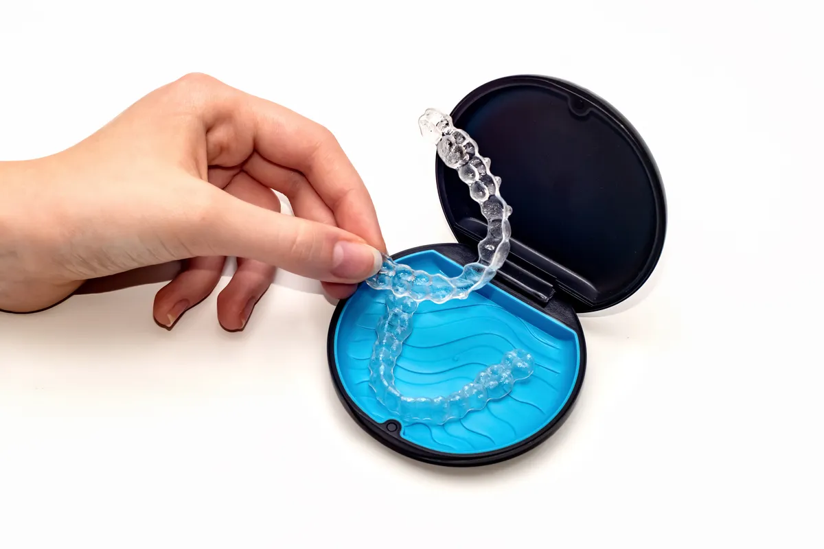 Clear aligner treatment materials laid out beside a storage case